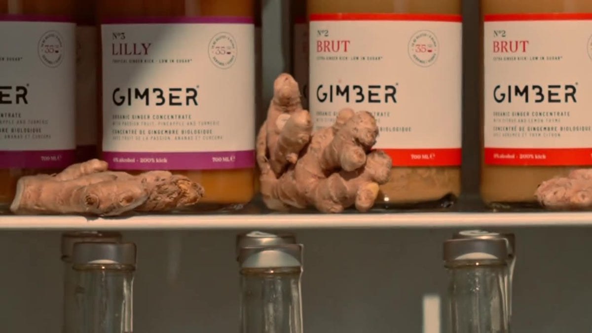Bouteilles de GIMBER N°2 Brut sur une étagère, avec du gingembre frais